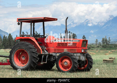 Brisco, BC/Kanada - 11. Juli 2018: Farm Traktor in einer Heu Feld in den kanadischen Rockies Stockfoto