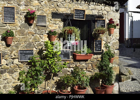 Restaurant La Casuca del Puente, durch eine Brücke über den Fluss Deva in Potes, Picos de Europa mit einer attraktiven Darstellung von Blumen und Menüs Stockfoto