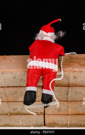 Santa Versuch, die Wand ein zuwanderungskonzept zu klettern Stockfoto