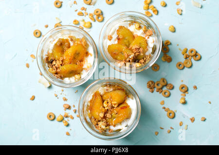 Karamellisierte Banane Parfait mit Müsli und Joghurt, hausgemachte Desserts, gesundes Frühstück Stockfoto