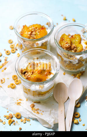 Karamellisierte Banane Parfait mit Müsli und Joghurt, hausgemachte Desserts, gesundes Frühstück Stockfoto