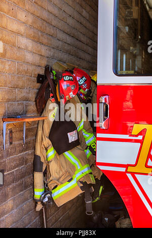 Uniformen der Feuerwehrleute und Frauen hängen an der Wand innerhalb einer Feuerwache in Tucson, AZ Stockfoto