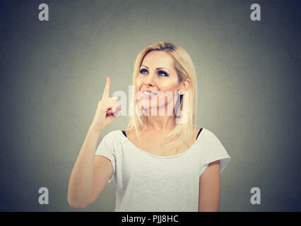 Porträt einer beiläufigen Frau mit Finger bis in helle Idee auf grauem Hintergrund Stockfoto