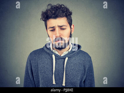 Porträt eines traurigen einsamen Jungen Mann, hat keine Energie, Motivation im Leben depressiv auf grauen Hintergrund isoliert Stockfoto