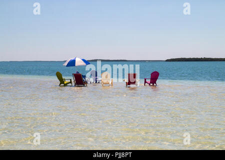 Liegestühle und Sonnenschirme am Sandstrand Konzept, Sandbar Island Wildlife Flüchtling, die während der Ebbe in Florida Keys, Key West erscheinen Stockfoto