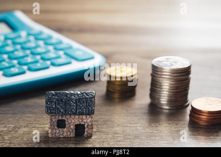 Haus Modell, Stapel von Münzen und Rechner. Konzept im Haus Verkauf, Kauf, Darlehen und Finance. Stockfoto