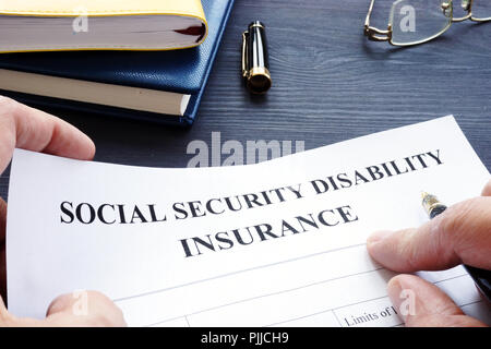 Man hält die Soziale Sicherheit Berufsunfähigkeitsversicherung SSDI Politik. Stockfoto