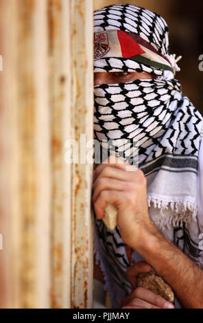 Nablus, Westjordanland. 7. Sep 2018. Eine maskierte Palästinensischen Demonstrant sieht während der Auseinandersetzungen mit der israelischen Streitkräfte nach einem wöchentlichen Demonstration gegen die Enteignung des palästinensischen Landes durch Israel im Dorf Kfar Qaddum, in der Nähe der Stadt Nablus im Westjordanland. Credit: Shadi Jarar'Ah/APA-Images/ZUMA Draht/Alamy leben Nachrichten Stockfoto