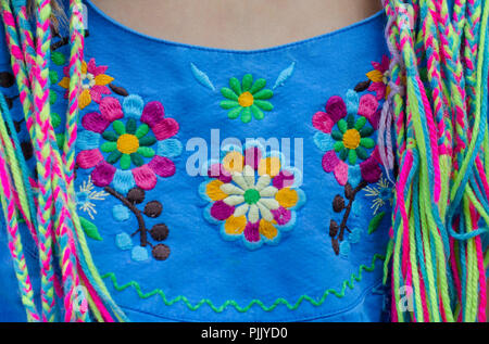 Mexikanische Stickerei mit buntem Zwirn auf blauem Hintergrund. Baumwollfaden Schulranzen. Stockfoto
