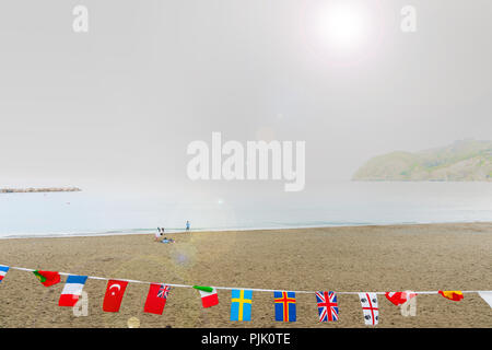 LEVANTE ITALIEN - 24. APRIL 2011; mediterranen Meer Strand mit Nationalflaggen aufgereiht im Vordergrund und entfernte kleine Gruppe im Hintergrund glar gefangen Stockfoto