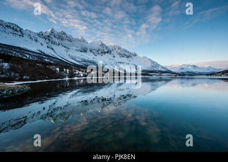 Reflexion der Lakselvtinden massiv über dem Dorf Lakselvbukt, südlichen Lyngen Alpen, Norwegen Stockfoto