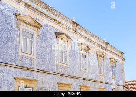 Abgenutzte Farbe erstellen eine interessante distressed Textur auf die Fassade dieses portugiesische Gebäude mit einem Dach Balustrade und Giebel Fenster arachiten Stockfoto