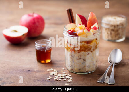 Über Nacht Hafer, Bircher Müsli mit Apfel, Zimt und Honig. Holz- Hintergrund Stockfoto