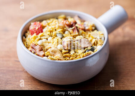 Müsli, Müsli in Keramik Schüssel. Gesundes Frühstück. Bio Hafer mit äpfeln, Beeren und Nüsse Stockfoto