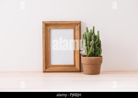 Moderne Dekoration. Verschiedene Kakteen und sukkulenten Pflanzen in verschiedenen Töpfen. Mock-up mit einem Holzrahmen. Stockfoto