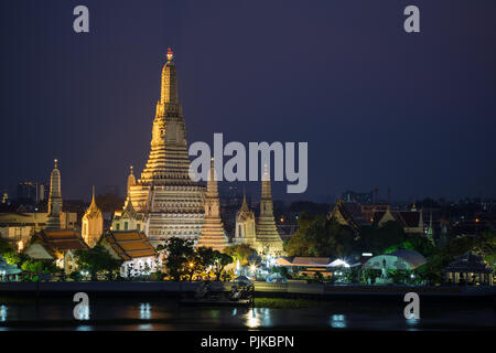 Schöne Aussicht von lit Wat Arun Tempel neben dem Chao Phraya Fluss in Bangkok, Thailand, am Abend. Stockfoto