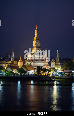 Schöne Aussicht von lit Wat Arun Tempel neben dem Chao Phraya Fluss in Bangkok, Thailand, am Abend. Stockfoto