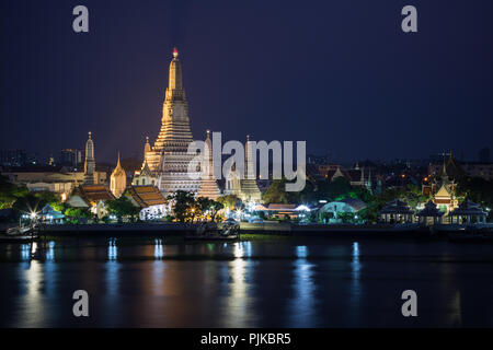 Schöne Aussicht von lit Wat Arun Tempel neben dem Chao Phraya Fluss in Bangkok, Thailand, am Abend. Stockfoto