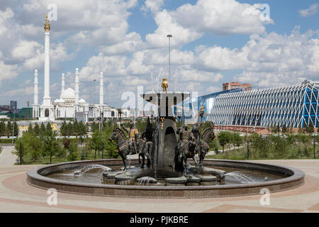 Astana, Kasachstan, 3. August 2018: Brunnen vor dem Nationalmuseum mit den Kazak Eli Denkmal und der Sultan Hazrat Moschee im Hintergrund Stockfoto