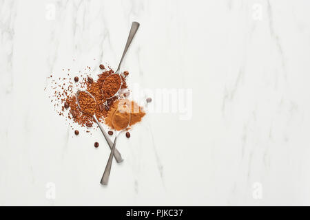Konzept der Kaffee Hintergrund. Flach der Löffel mit Kaffeebohnen, Boden und Instantkaffee auf Marmor Hintergrund. Ansicht von oben mit der Kopie. Stockfoto