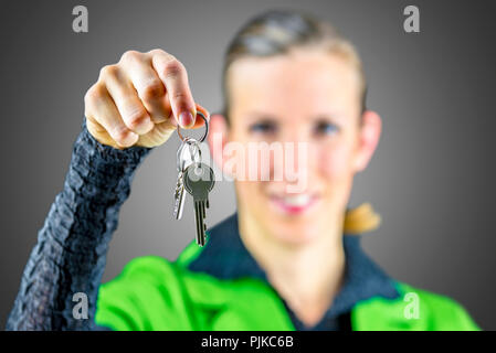 Junge weibliche real estate agent bietet Ihnen Haus Tasten. Stockfoto