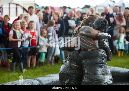 Zwei Frauen mud Wrestling mit einer Menge hinter im Tiefland Spiele, Thorney, Somerset, England Stockfoto