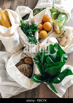 Null Abfall shopping Konzept. frisches Gemüse im eco Baumwolle Taschen am Tisch in der Küche, flach. verbot Kunststoff Kunststoff freie Einzelteile. Umwelt speichern Stockfoto