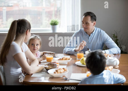 Glückliche Eltern mit zwei Kindern genießen Sie gesundes Frühstück zu Hause Stockfoto
