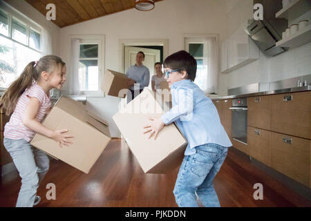 Aufgeregt Kinder Spaß bringen in Schachteln zu neuen Haus Stockfoto