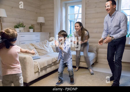 Kleine Mädchen mit verbundenen Augen, mit Versteck spielen und mit Familie suchen Stockfoto