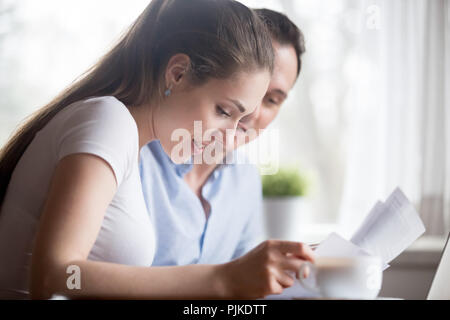 Nahaufnahme des glücklichen Paares lesen gute Nachrichten auf Dokumente Stockfoto