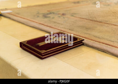 Das Buch mit dem Kreuz trägt den Glauben, das auf dem Altar ist. Stockfoto