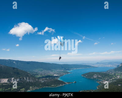 Gleitschirm über den Lac d'Annecy scheint die Wolken berühren Stockfoto