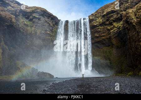 Island, Skógar, Skógafoss im Süden von Island, Person stand vor der Wasserfall, Stockfoto