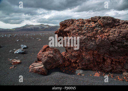 Island, die vulkanische Wüste Lambafitjarhraun, rote und blaue Steine auf schwarzem Sand, Cloud Stimmung Stockfoto