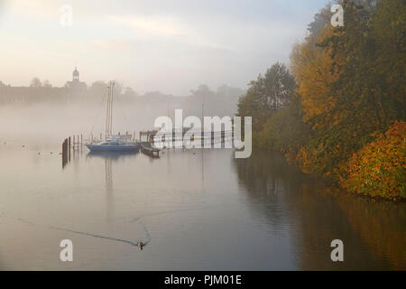 Misty Herbst morgen über den Großen Eutiner See. Blick auf die Burg. Stockfoto
