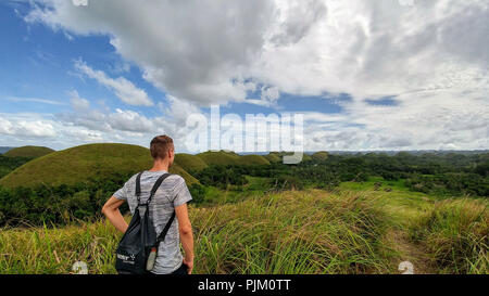 Wanderer betrachtet die Chocolate Hills auf Bohol, Philippinen Stockfoto