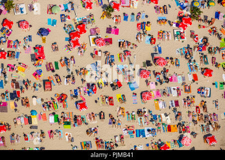 Sonnenuntergang Strand, die Badegäste auf Handtücher, am heißesten Tag im Frühjahr 2015, Escher See, Wasser, Rot , rot Sonnenschirme, weißen Strand, Palmen und Strohhütten 'South Meer Feeling' am Escher See in Köln, Badesee, Köln, Rheinland, Nordrhein-Westfalen, Deutschland Stockfoto