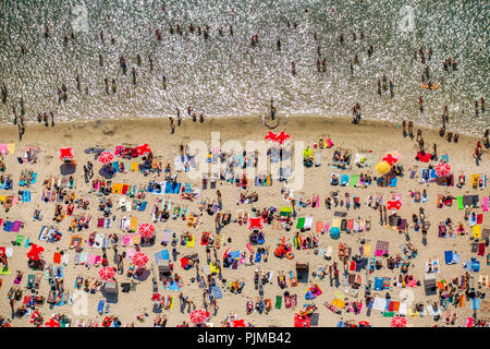 Sonnenuntergang Strand, die Badegäste auf Handtücher, am heißesten Tag im Frühjahr 2015, Escher See, Wasser, Rot , rot Sonnenschirme, weißen Strand, Palmen und Strohhütten 'South Meer Feeling' am Escher See in Köln, Badesee, Köln, Rheinland, Nordrhein-Westfalen, Deutschland Stockfoto