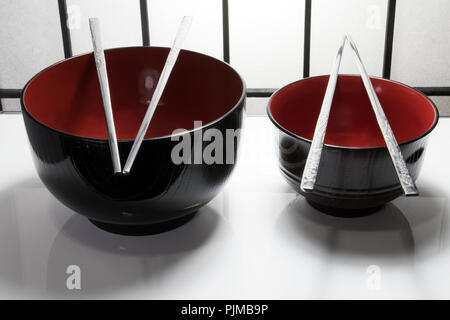 Tisch in einem Restaurant mit Gerichten, Futternäpfe und Essstäbchen. Asiatisch Japanisch, Koreanisch, Chinesisch, Vietnamesisch Reis und Nudeln Suppenschüsseln. Stockfoto