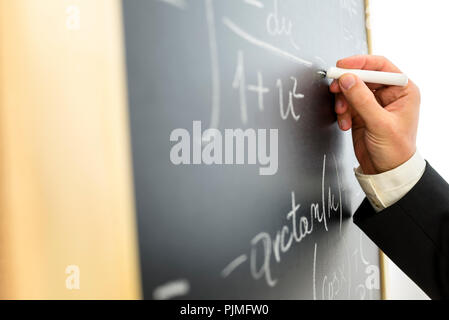 Nahaufnahme der Hochschule Mathematik Professor schreiben komplizierte Gleichung auf dem Schwarzen Brett. Stockfoto