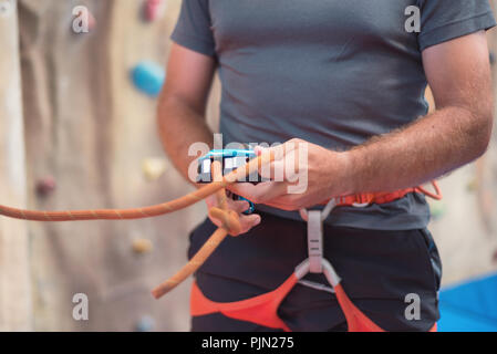 Rock Wall climber tragen und Kletterausrüstung Indoor, Nahaufnahme Stockfoto