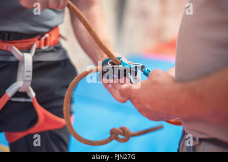 Rock Wall climber tragen und Kletterausrüstung Indoor, Nahaufnahme Stockfoto