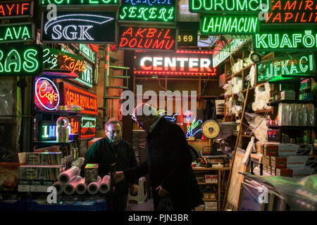 ISTANBUL, Türkei - 29 Dezember, 2015: Zwei türkische Männer diskutieren in einem kleinen Laden mit Neon und LED-Leuchten für die Unternehmen vor allem Restaurants und Caf Stockfoto