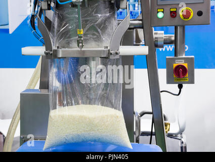 Reis füllen sie in Kunststoff durch Verpackungsmaschine; bis schließen Stockfoto