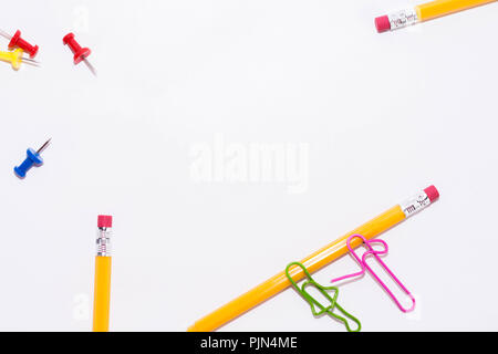 Zwei Büroklammern sprechen beim Liegen auf einem weissen Stock und auf einem Bleistift. Miniatur Schule leben und zurück in die Schule Konzept mit Kopie Raum weiß backgroun Stockfoto