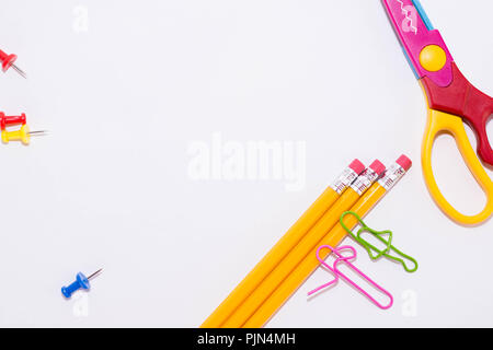 Zwei Büroklammern sprechen beim Liegen auf einem weissen Stock und auf einem Bleistift. Miniatur Schule leben und zurück in die Schule Konzept mit Kopie Raum weiß backgroun Stockfoto