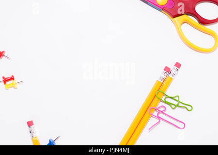 Zwei Büroklammern sprechen beim Liegen auf einem weissen Stock und auf einem Bleistift. Miniatur Schule leben und zurück in die Schule Konzept mit Kopie Raum weiß backgroun Stockfoto