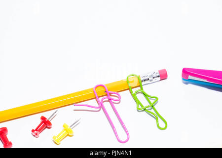 Zwei Büroklammern sprechen beim Liegen auf einem weissen Stock und auf einem Bleistift. Miniatur Schule leben und zurück in die Schule Konzept mit Kopie Raum weiß backgroun Stockfoto