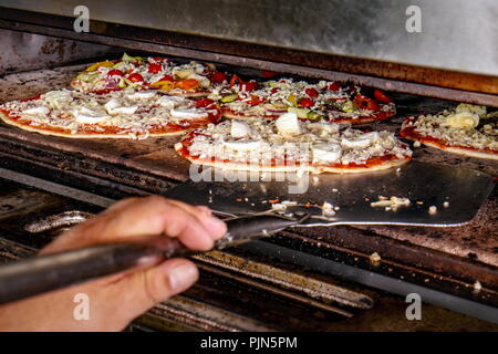 Koch, Pizza bereit für das Backen im Backofen Stockfoto